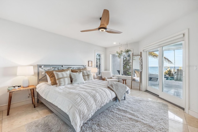 tiled bedroom featuring access to outside, ceiling fan, and a water view