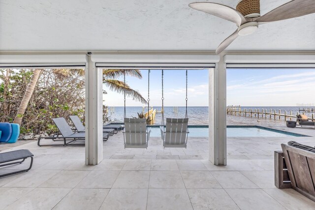 view of patio featuring a water view and ceiling fan