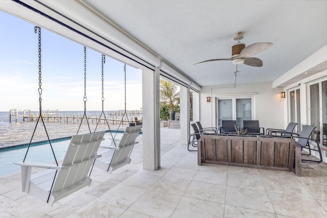 exterior space featuring ceiling fan and a water view