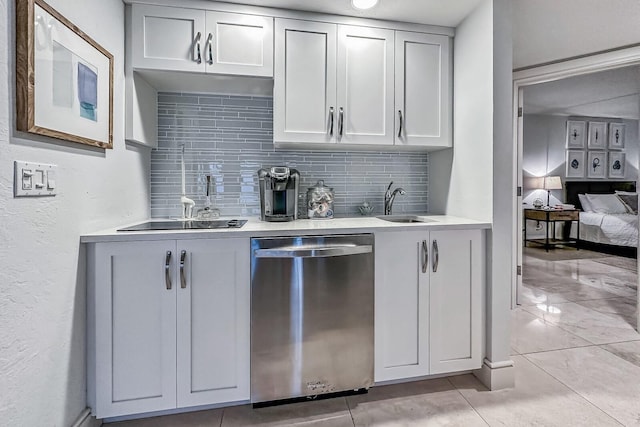 kitchen with backsplash, dishwasher, light tile patterned floors, and sink