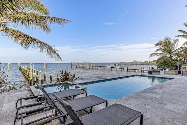 view of pool with an in ground hot tub, a boat dock, and a water view