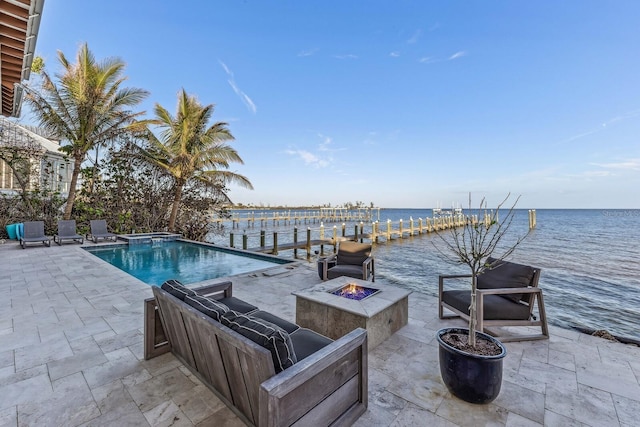 view of swimming pool featuring a boat dock, a water view, a fire pit, and a patio area