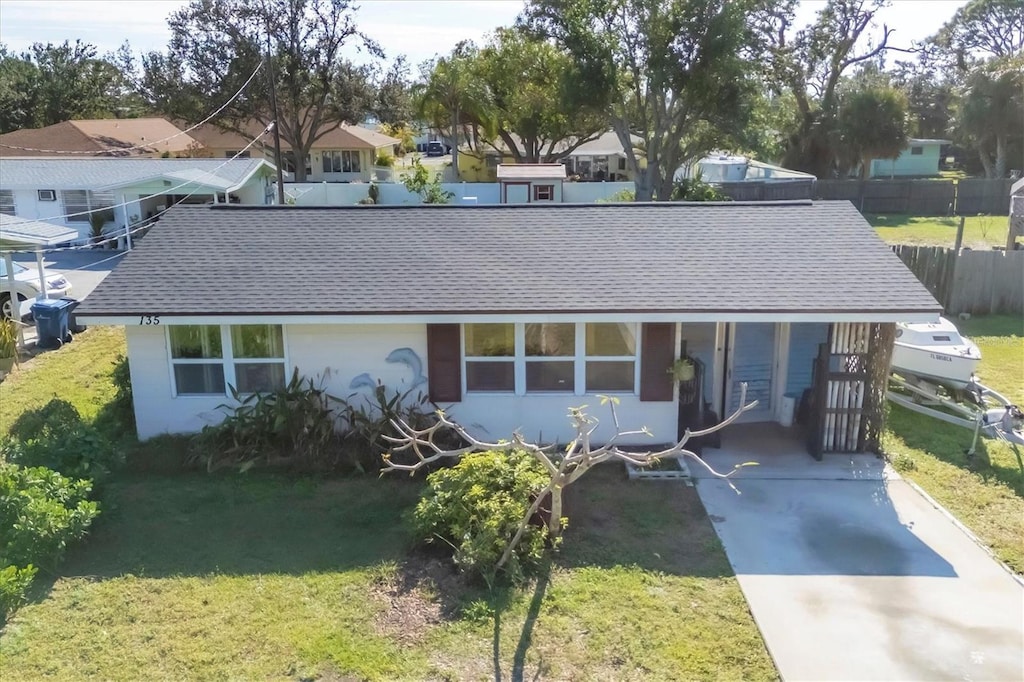 view of front of home with a front yard and a carport