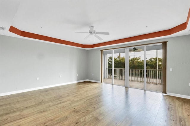 empty room with ceiling fan and light hardwood / wood-style flooring