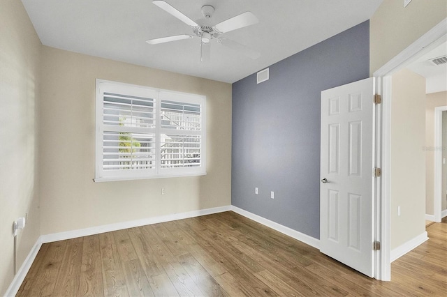 spare room with light wood-type flooring and ceiling fan