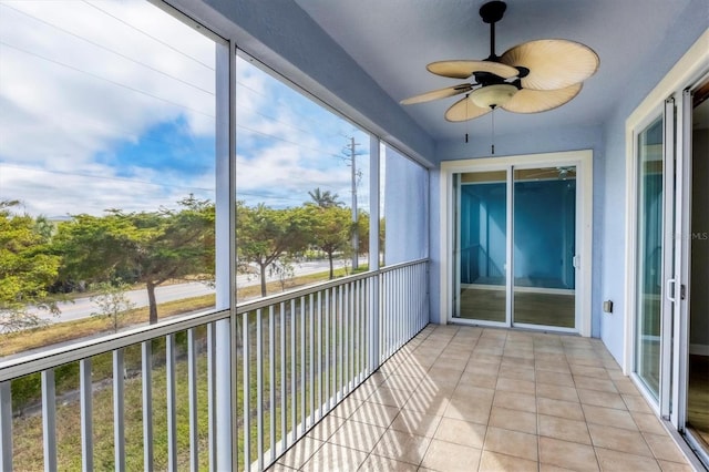 unfurnished sunroom with ceiling fan