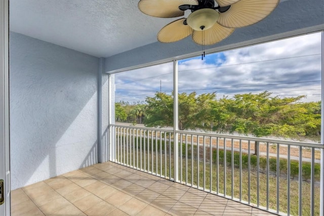 unfurnished sunroom with ceiling fan