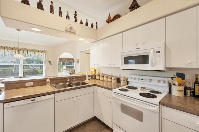 kitchen featuring decorative light fixtures, white cabinetry, white appliances, and sink