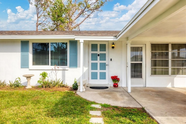 doorway to property featuring a lawn