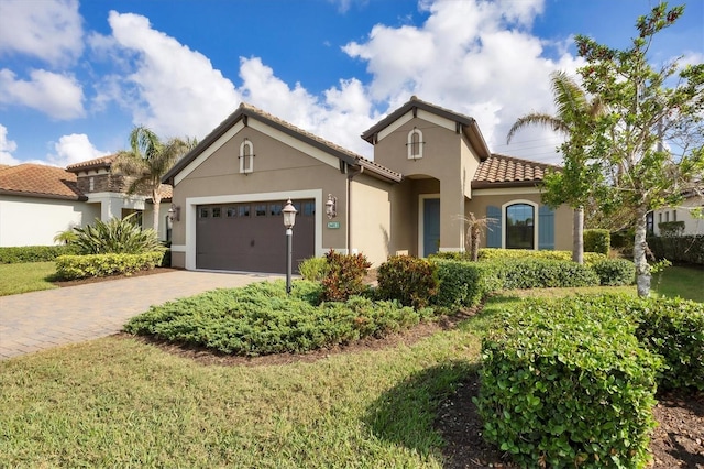 mediterranean / spanish-style house with a front yard and a garage