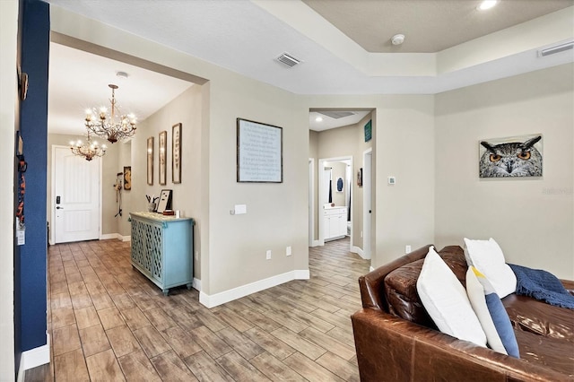 living room with a raised ceiling and a chandelier