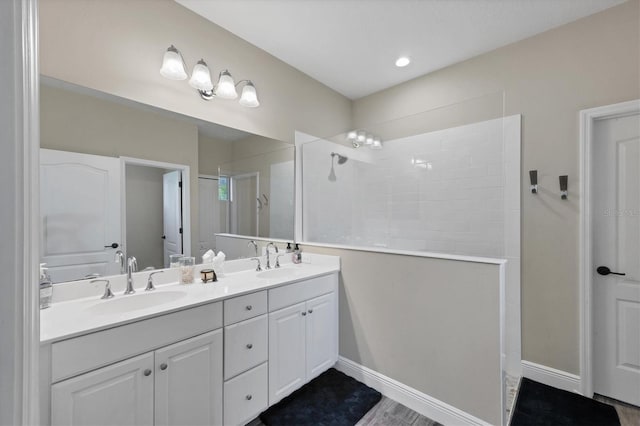 bathroom with hardwood / wood-style floors, vanity, and walk in shower