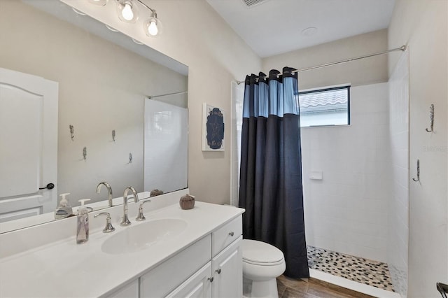 bathroom with walk in shower, toilet, vanity, and hardwood / wood-style flooring