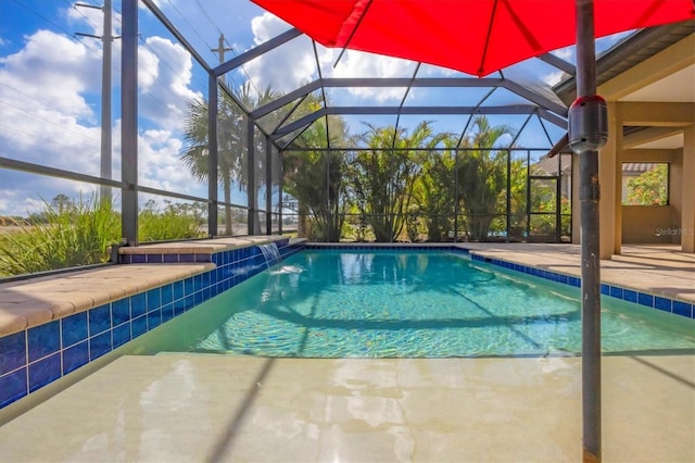 view of swimming pool with pool water feature, glass enclosure, and a patio