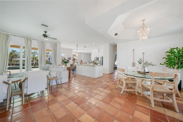 dining area with ceiling fan with notable chandelier and light tile patterned floors