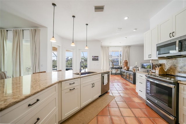 kitchen featuring white cabinets, sink, decorative backsplash, light stone countertops, and appliances with stainless steel finishes