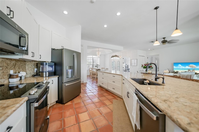 kitchen with backsplash, ceiling fan with notable chandelier, stainless steel appliances, sink, and white cabinets