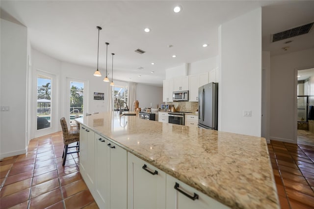 kitchen featuring light stone countertops, appliances with stainless steel finishes, decorative backsplash, sink, and white cabinetry