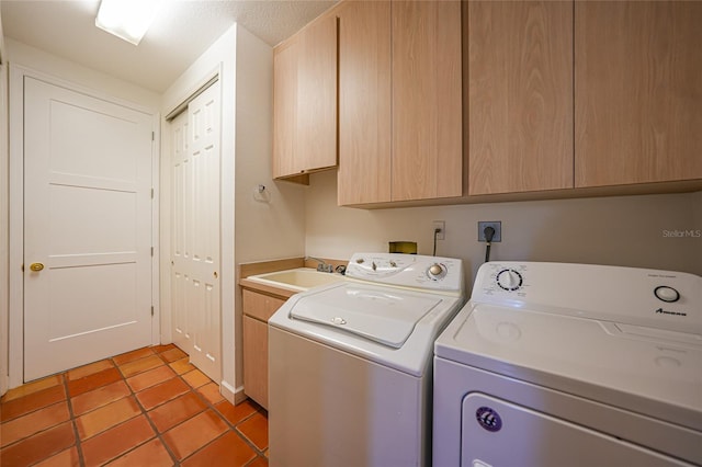 laundry room featuring cabinets, a textured ceiling, washer and clothes dryer, sink, and light tile patterned floors