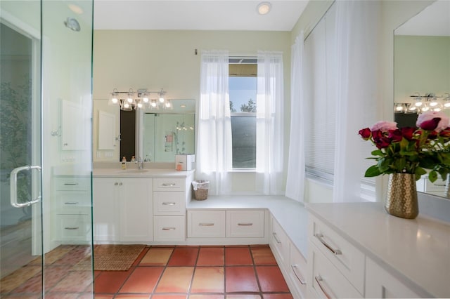 bathroom with tile patterned floors, a wealth of natural light, vanity, and walk in shower