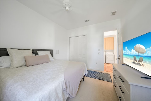 carpeted bedroom featuring washer and clothes dryer and a closet