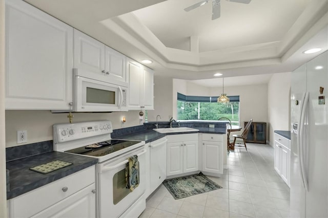 kitchen featuring white cabinetry, white appliances, kitchen peninsula, and a tray ceiling