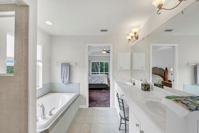 bathroom featuring tile patterned floors, plenty of natural light, vanity, and a relaxing tiled tub