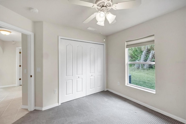 unfurnished bedroom with ceiling fan, light tile patterned floors, and a closet