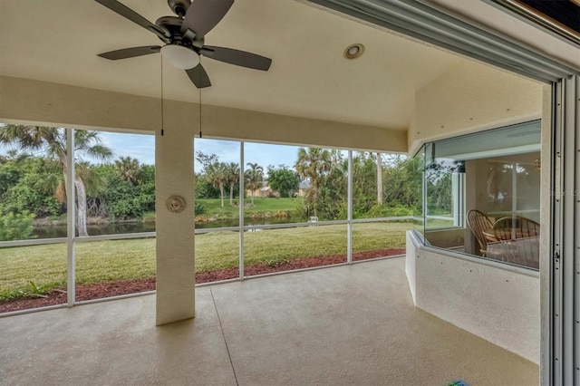 unfurnished sunroom with a water view and ceiling fan