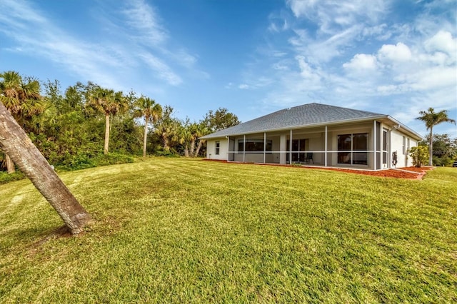 rear view of property featuring a lawn and a sunroom