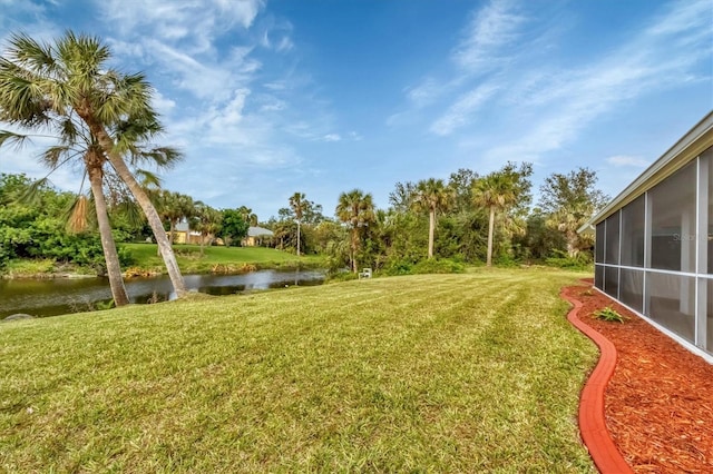 view of yard with a water view and a sunroom