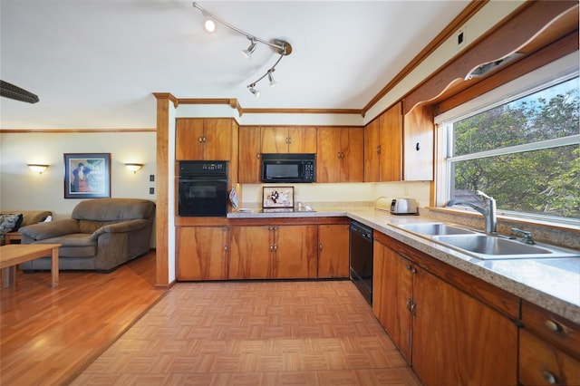 kitchen with black appliances, ornamental molding, sink, and light parquet floors