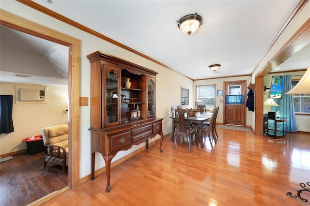 dining area featuring a wall mounted AC, crown molding, and hardwood / wood-style flooring