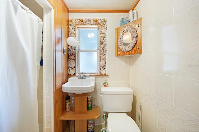 bathroom featuring crown molding, sink, a shower with shower curtain, toilet, and tile walls