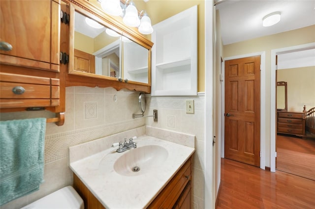 bathroom featuring wood-type flooring, vanity, and tasteful backsplash