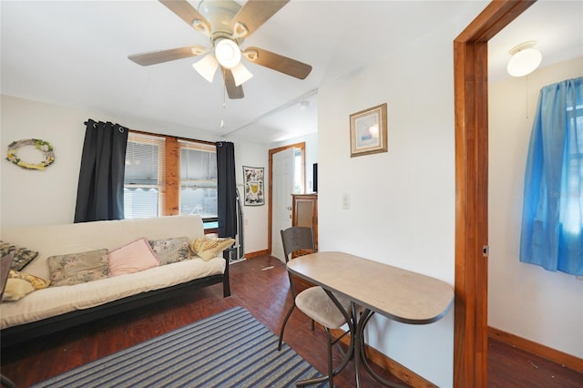 living room featuring ceiling fan and dark wood-type flooring