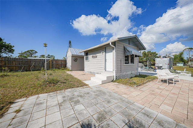 exterior space featuring a patio, a storage shed, and a lawn