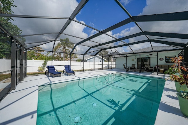 view of swimming pool with a patio, ceiling fan, and a lanai