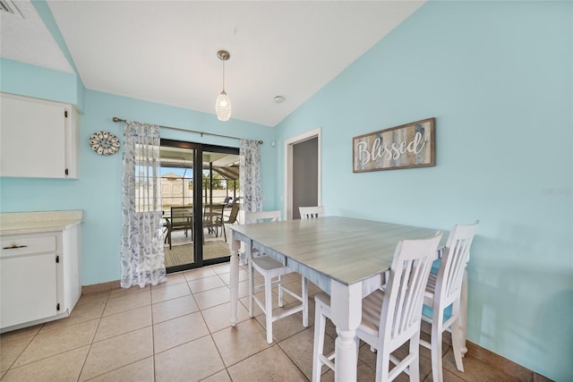 tiled dining space featuring vaulted ceiling