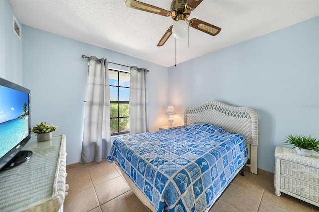 bedroom featuring tile patterned flooring, a textured ceiling, and ceiling fan