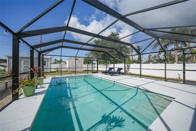 view of swimming pool with a shed, a lanai, and a patio area