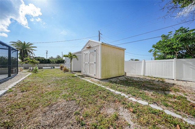 view of yard with glass enclosure and a storage unit