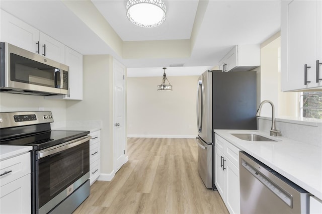 kitchen with white cabinets, stainless steel appliances, light hardwood / wood-style floors, and sink