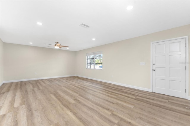 empty room with ceiling fan and light hardwood / wood-style flooring