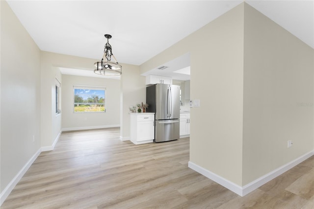 interior space featuring light hardwood / wood-style floors and a notable chandelier