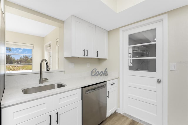 kitchen featuring white cabinetry, dishwasher, light wood-type flooring, and sink