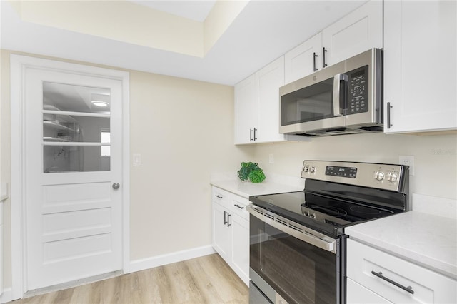 kitchen featuring light hardwood / wood-style flooring, white cabinets, and appliances with stainless steel finishes