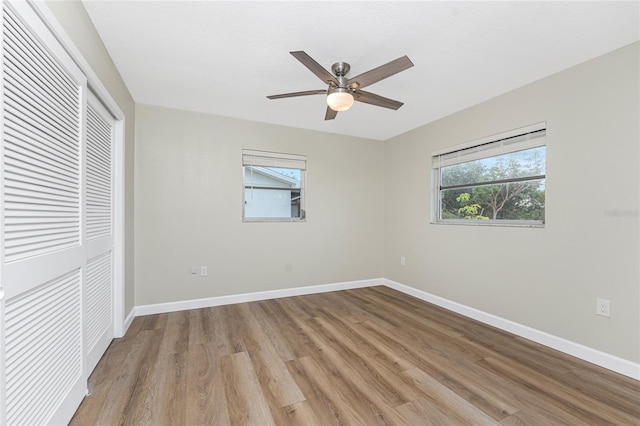 unfurnished bedroom featuring ceiling fan, a closet, and light wood-type flooring