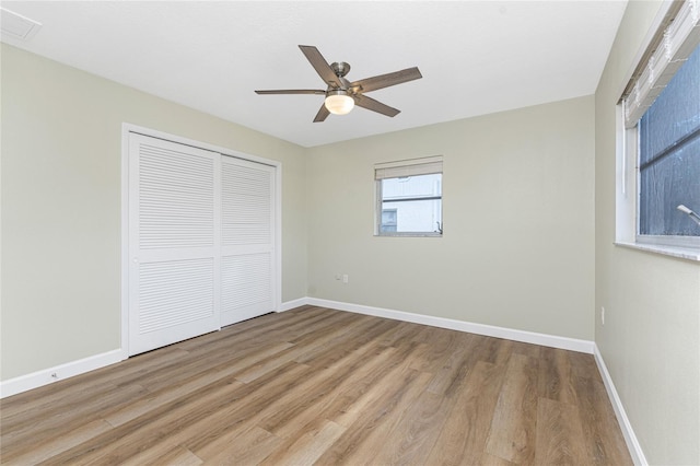 unfurnished bedroom with light wood-type flooring, a closet, and ceiling fan