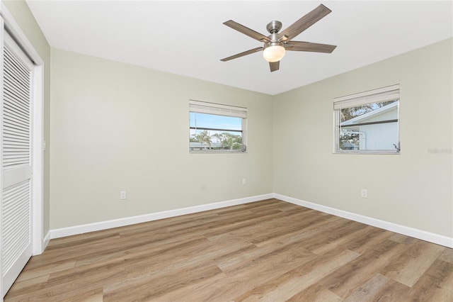 unfurnished bedroom featuring ceiling fan, a closet, and light wood-type flooring